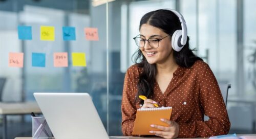 Person wearing headphones working on a laptop computer